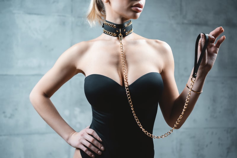 bondage toys and gear on a woman in black